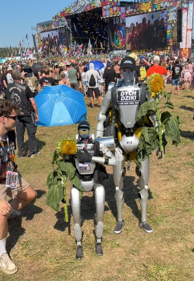 Edek and a robot dog decorated with sunflowers in a festival crowd