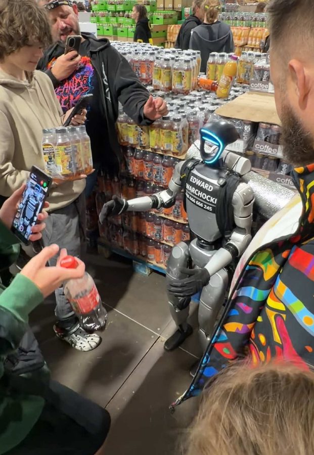 Edek at a drinks stand handing out cans